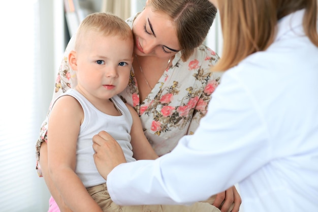 Médico examinando um paciente infantil por estetoscópio