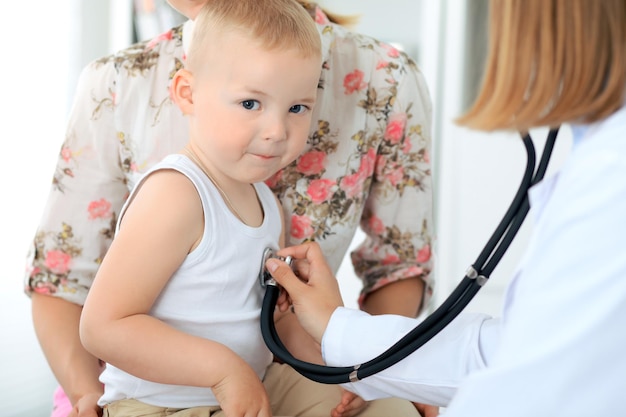 Médico examinando um paciente infantil por estetoscópio