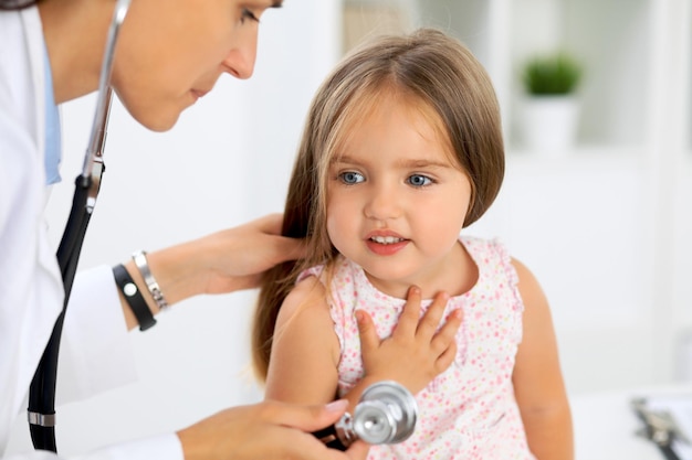 Médico examinando uma garotinha pelo estetoscópio.