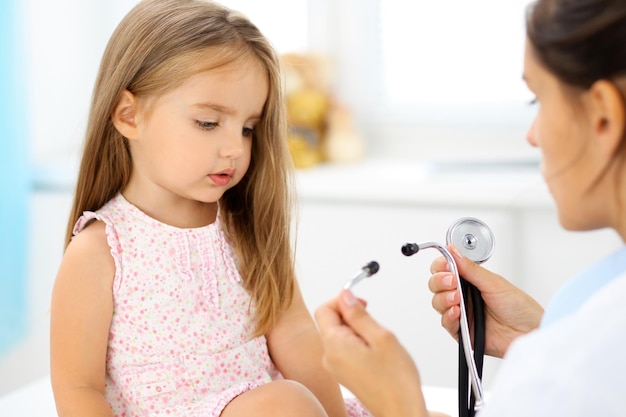 Foto médico examinando uma garotinha pelo estetoscópio.