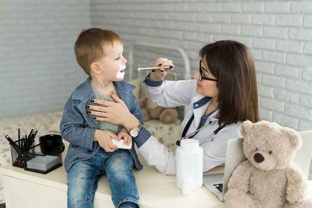 Foto médico examinar a garganta da criança