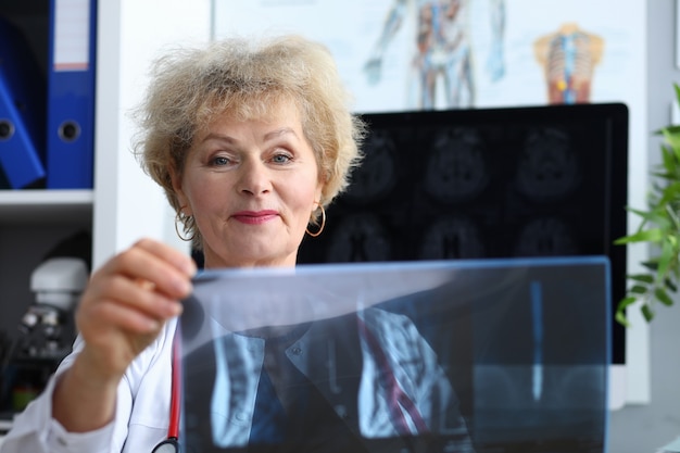 Médico experimentado mujer mirando una imagen de rayos x