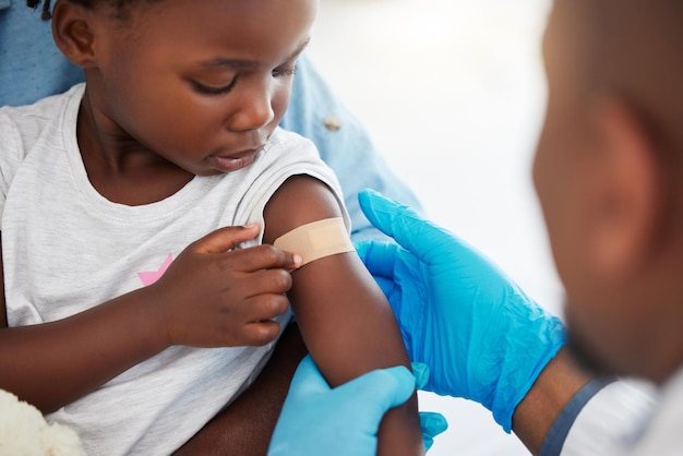 Médico experto en atención médica y trabajador médico con yeso en el brazo de un niño enfermo después de la ayuda de la vacuna covid con emergencia médica y consulta con el paciente en el hospital Niña con vendaje después de una lesión