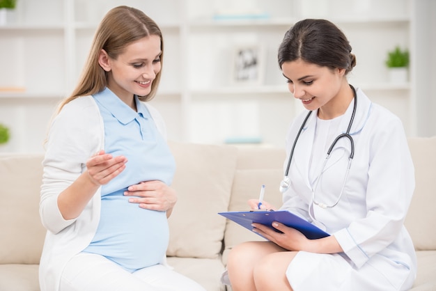 Médico explicando algo para seu paciente grávida.