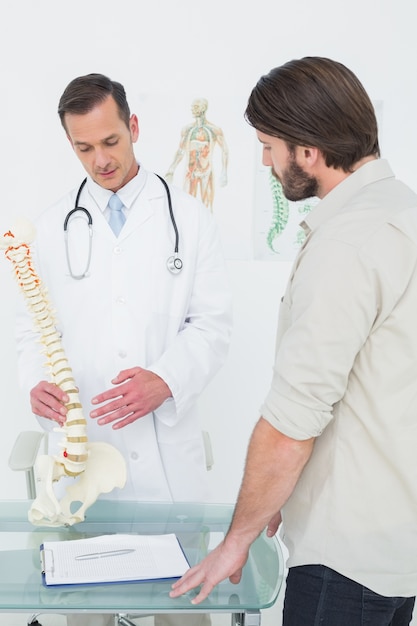 Médico explicando la columna vertebral a un paciente