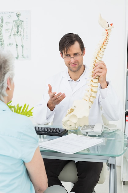 Médico explicando la columna vertebral a un paciente