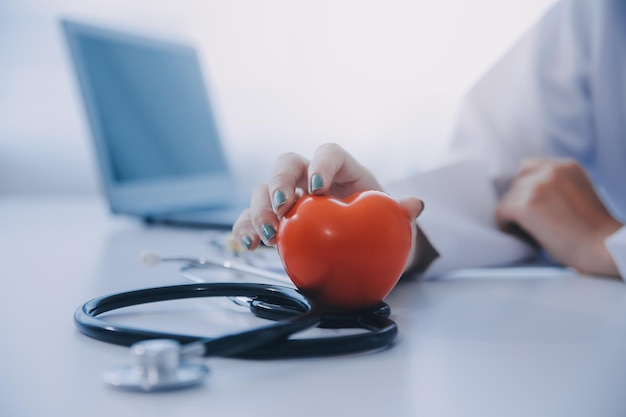 Médico explicando o coração a um paciente idoso Médico explicado o modelo de coração Médicos apontam a caneta para um modelo de coração