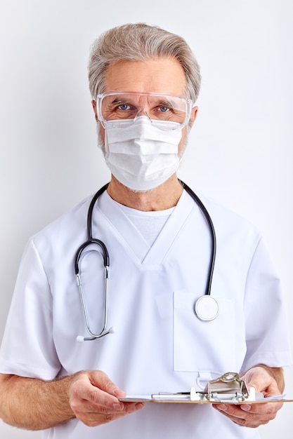 Médico fala sobre o diagnóstico, segurando o tablet nas mãos e usando uma máscara médica protetora, isolado no espaço em branco