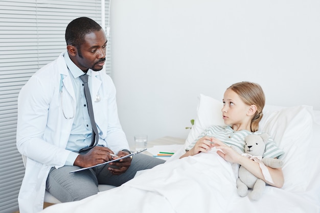 Médico falando com criança no hospital