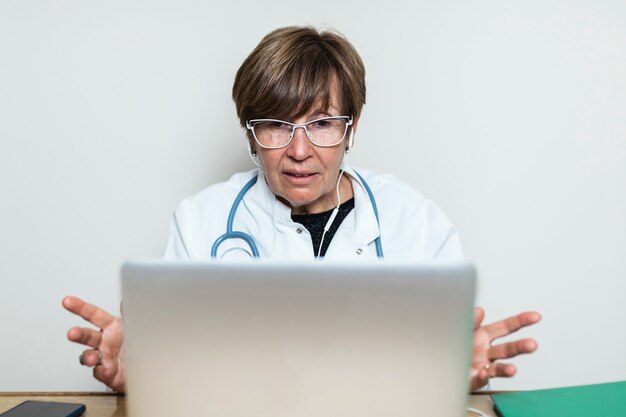 Médico falando com o paciente por meio de videochamada no laptop e dando conselhos médicos. Consulta de telemedicina