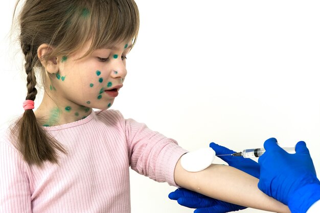 Médico fazendo injeção de vacinação em uma menina criança com medo de varicela, sarampo ou vírus da rubéola