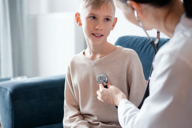 Médico y feliz niño sonriente niño paciente en casa inspección médica. Medicina, conceptos sanitarios