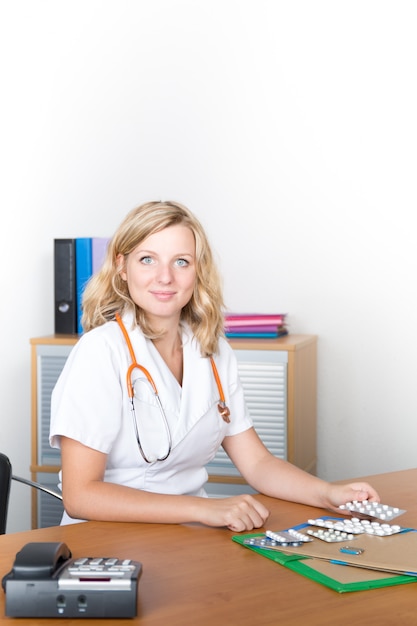 Médico feminino atraente, trabalhando em seu laptop em seu escritório