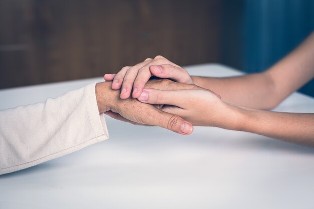 Médico feminino médico mãos segurando a mão do paciente para encorajamento