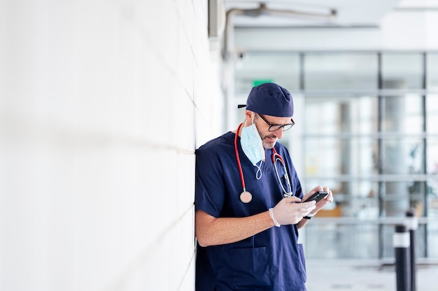 Médico fora do hospital usando smartphone