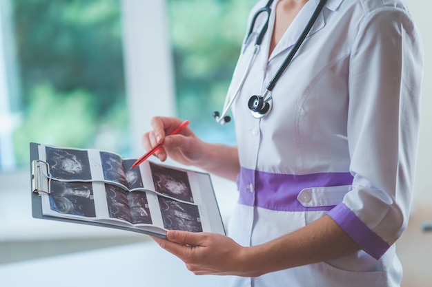 El médico general examina las imágenes de ultrasonido del paciente durante un chequeo de salud y consulta. Salud y medicina