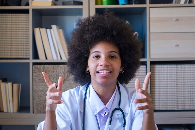Médico general sonriente consulta al paciente en línea por videollamada Retrato de una doctora afroamericana feliz mirando a la cámara Trabajador de la salud que consulta a un paciente de la clínica en línea
