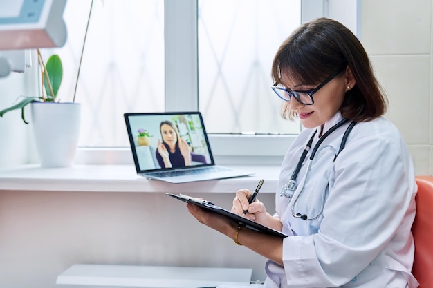 Médico generalista hablando por videoconferencia con una paciente