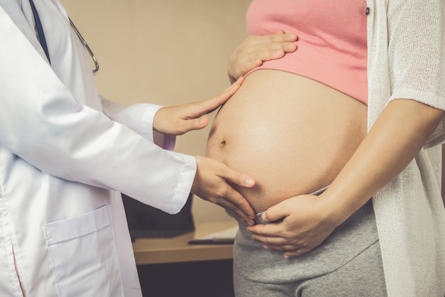 Médico de ginecólogo y mujer embarazada en el hospital