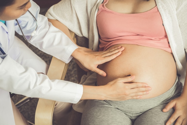 Foto médico de ginecólogo y mujer embarazada en el hospital