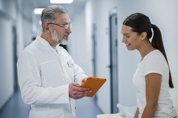 Foto médico grisalho falando com o paciente antes de ressonância magnética