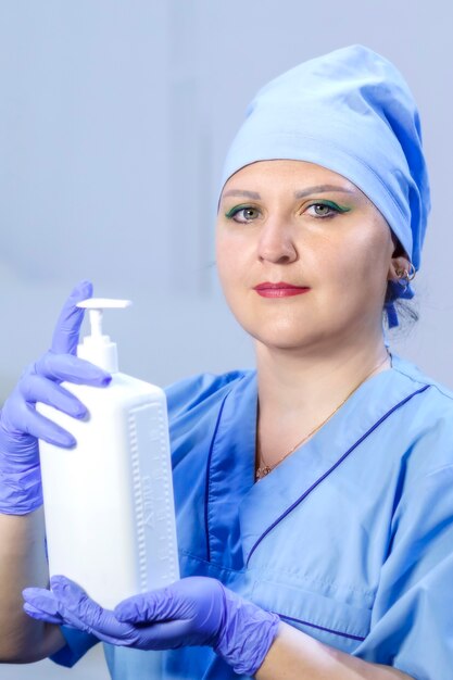 Foto un médico con guantes médicos tiene un antiséptico en sus manos. foto vertical