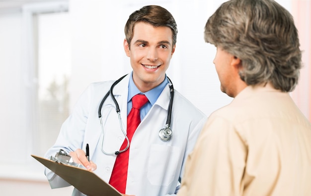 Médico guapo haciendo la vacunación al paciente masculino en el fondo