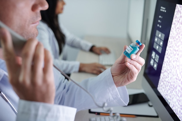 Médico hace una llamada telefónica para discutir los efectos secundarios de la nueva vacuna contra el coronavirus