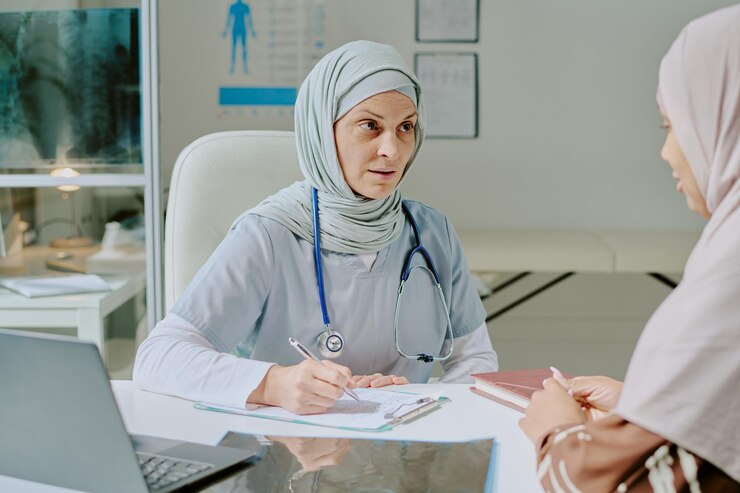 Foto médico con hijab discutiendo con un paciente en la oficina