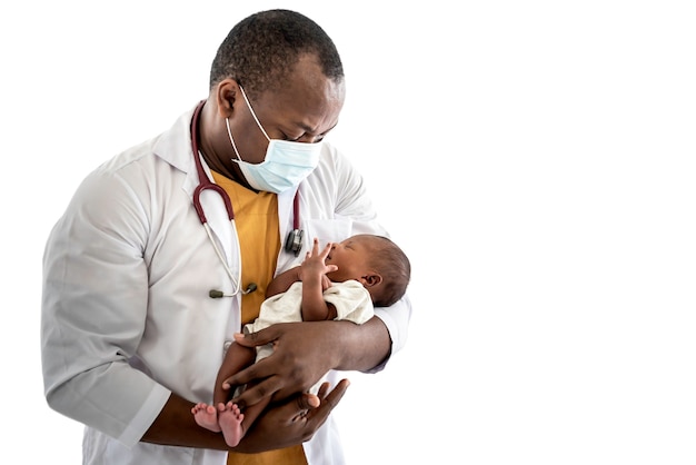 Médico hombre africano con una mascarilla quirúrgica sosteniendo un bebé recién nacido de piel negra