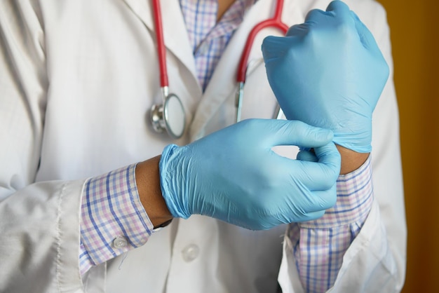 Médico hombre lleva guantes médicos de cerca