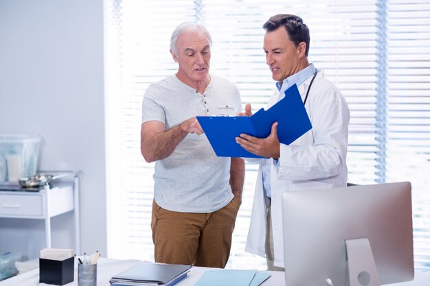 Médico y hombre mayor discutiendo en el archivo