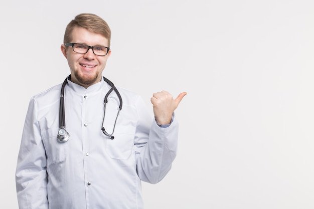 Médico homem apontando o dedo para o espaço da cópia, isolado no fundo branco. Conceito médico.