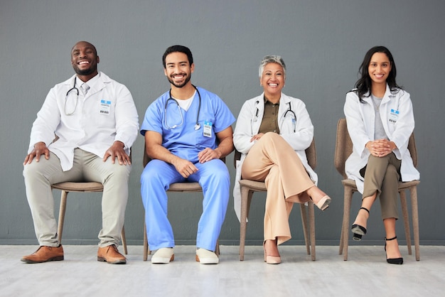 Médico del hospital y retrato de un grupo en una silla sobre fondo de pared para bienestar de seguros y atención médica Trabajo en equipo de atención médica y hombres y mujeres sentados en fila para consultar apoyo y servicio