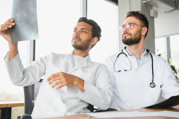 Un médico indio y un médico europeo juntos en el vestíbulo de un hospital