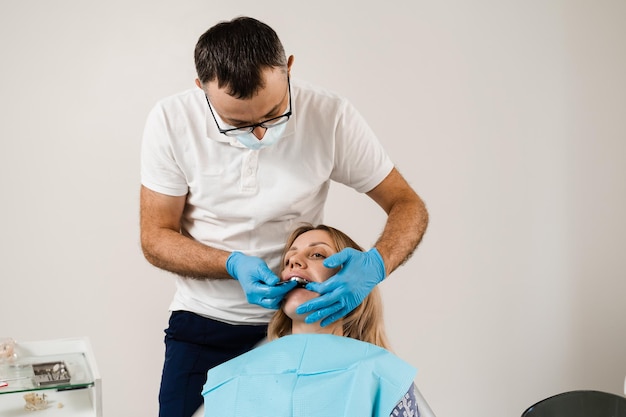 El médico inserta la bandeja de impresión y hace el molde de dientes al paciente en odontología antes de la implantación dental Procedimiento de creación de coronas y alineadores de prótesis dentales