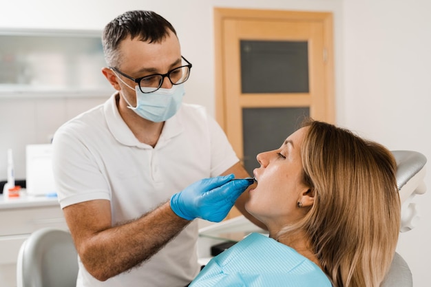 El médico inserta la bandeja de impresión y hace el molde de dientes al paciente en odontología antes de la implantación dental Procedimiento de creación de coronas y alineadores de prótesis dentales