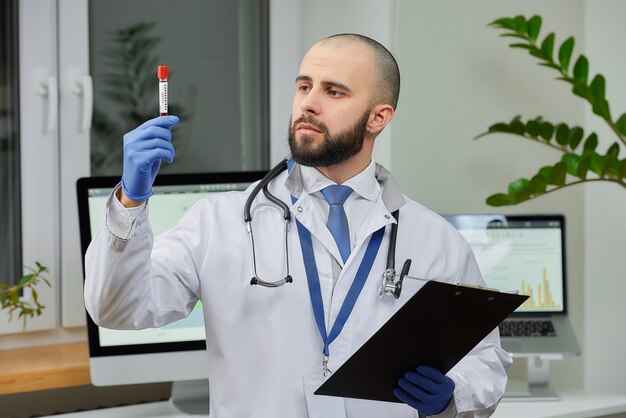 Un médico investigando un análisis de sangre de coronavirus en un laboratorio.