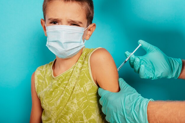 Médico inyecta vacuna a un niño contra el coronavirus covid
