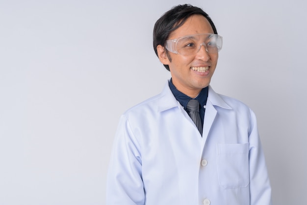 Médico japonés con gafas protectoras contra el fondo blanco.