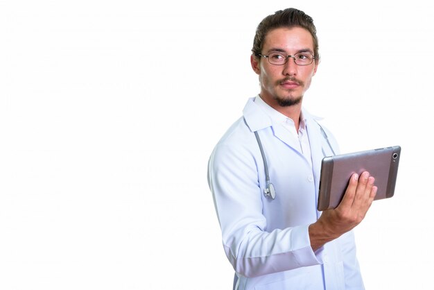 Médico jovem bonito segurando o tablet digital