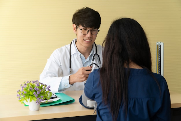 Médico jovem e bonito, dando uma consulta a um paciente e explicar informações médicas