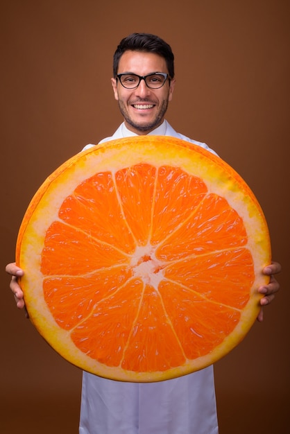 Foto médico jovem hispânico bonito contra um fundo marrom