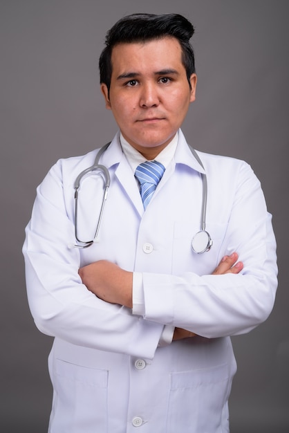 Médico jovem multi-étnica contra parede cinza