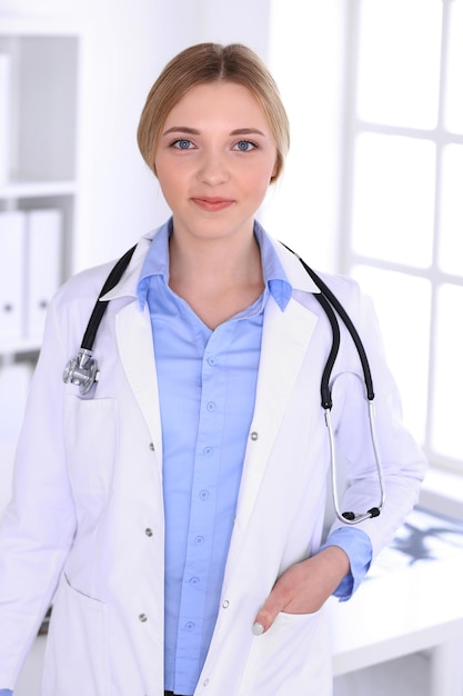 Médico jovem no trabalho no hospital, olhando para a câmera. Blusa de cor cáqui de terapeuta fica bem. Conceito de medicina e saúde.