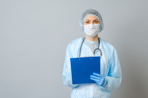 Médico joven con estetoscopio prescribiendo tratamiento al paciente. Doctora con receta de escritura de pluma en el portapapeles. Aislado en gris