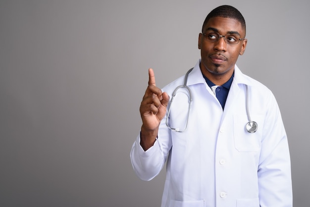 Médico joven guapo africano en gris