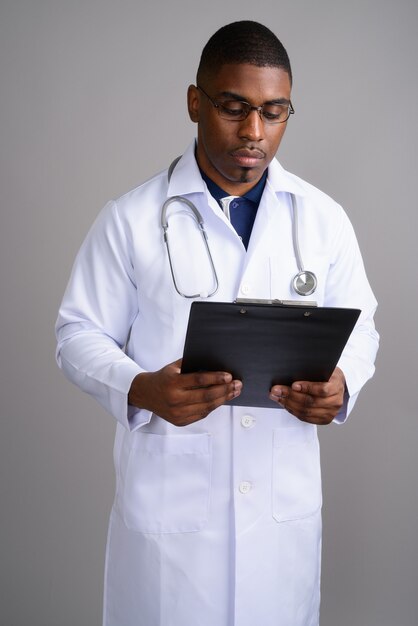 Médico joven guapo africano en gris