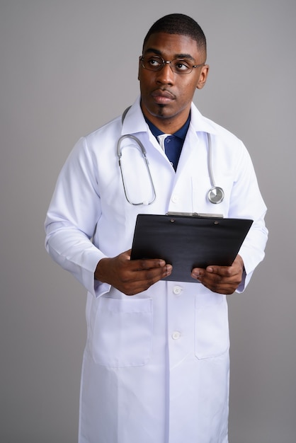 Médico joven guapo africano en gris