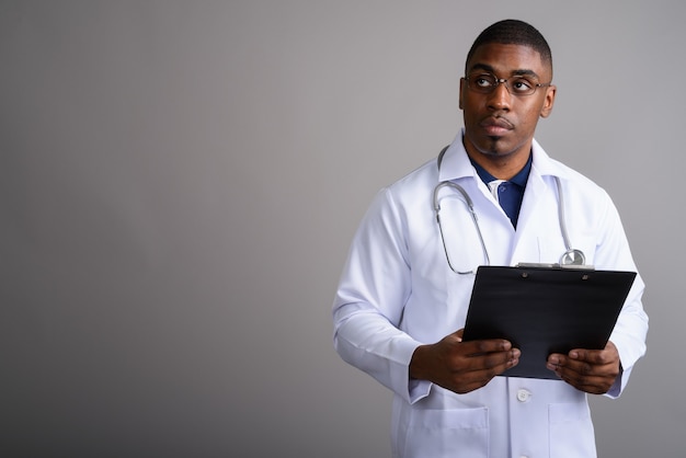 Médico joven guapo africano en gris